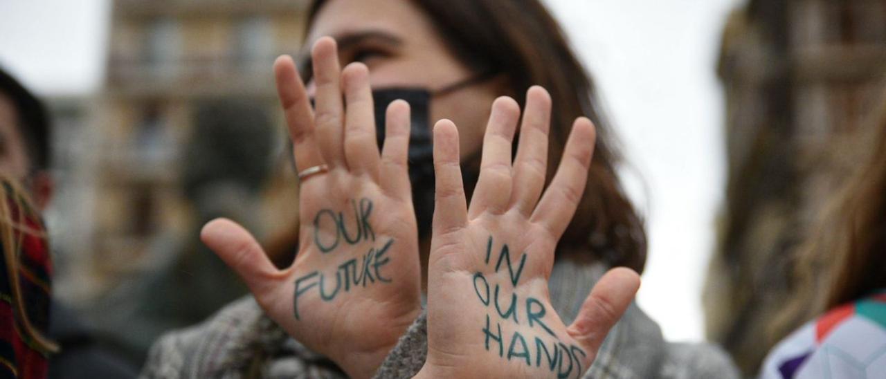 Una joven muestra la frase ‘Nuestro futuro en nuestras manos’, en inglés, durante una concentración por el clima convocada en Valencia por el movimiento internacional Fridays For Future. |   // JORGE GIL