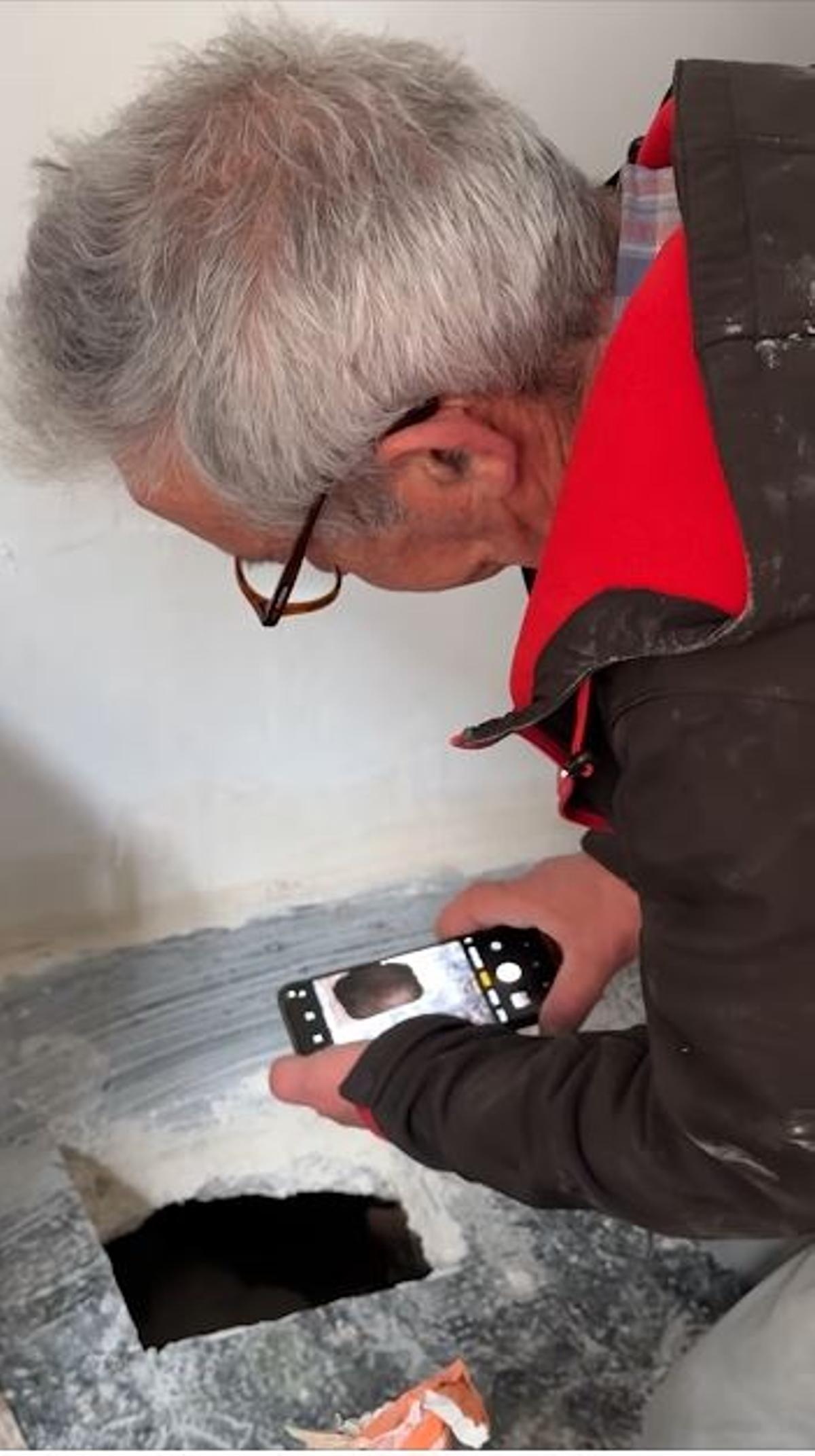 Macián fotografiando dentorde una casa.
