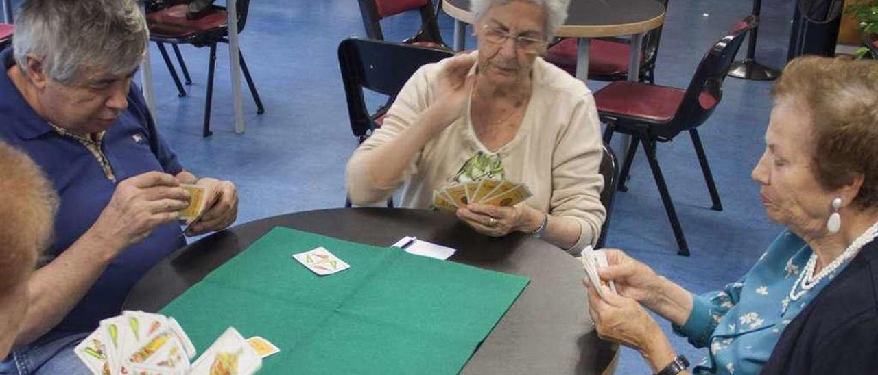 De izquierda a derecha, Alfredo Otero, Palmira Fernández y Ana Pérez jugando a las cartas.