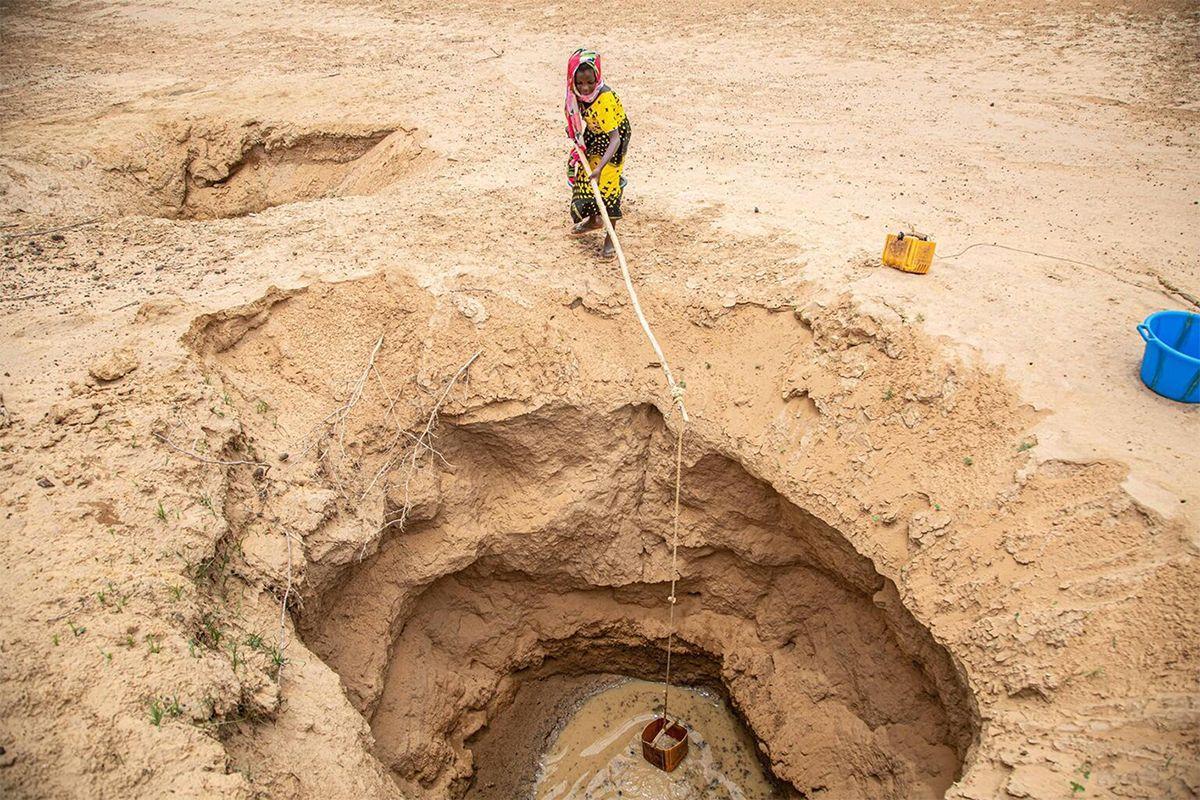 Una mujer extrae agua en un pozo subterráneo.
