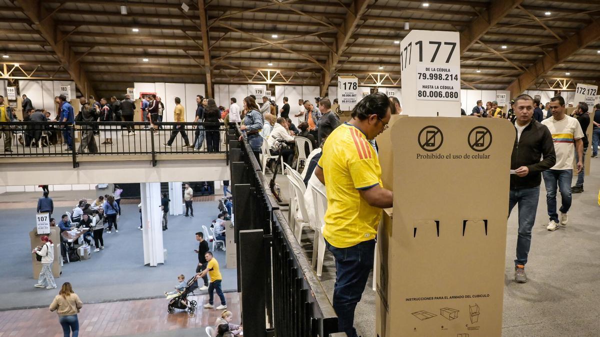 Ciudadanos colombianos visten la camiseta amarilla de su Selección de fútbol en la segunda vuelta de las elecciones presidenciales 2026