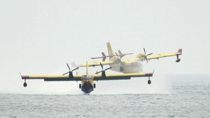 Dos hidroaviones se cruzan tras cargar agua en el mar.