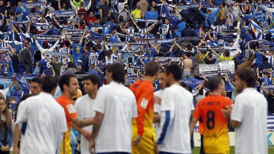 Los jugadores del Espanyol hacen pasillo a los del Barça con seguidores blanquiazules dando la espalda al campo.