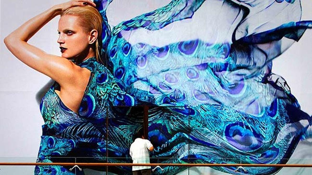 Un treballador obre les portes d’una luxosa galeria comercial construïda al centre de Singapur poques hores abans de la inauguració.