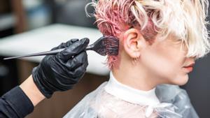 Archivo - Mujer tiñéndose el pelo en una peluquería, tinte.