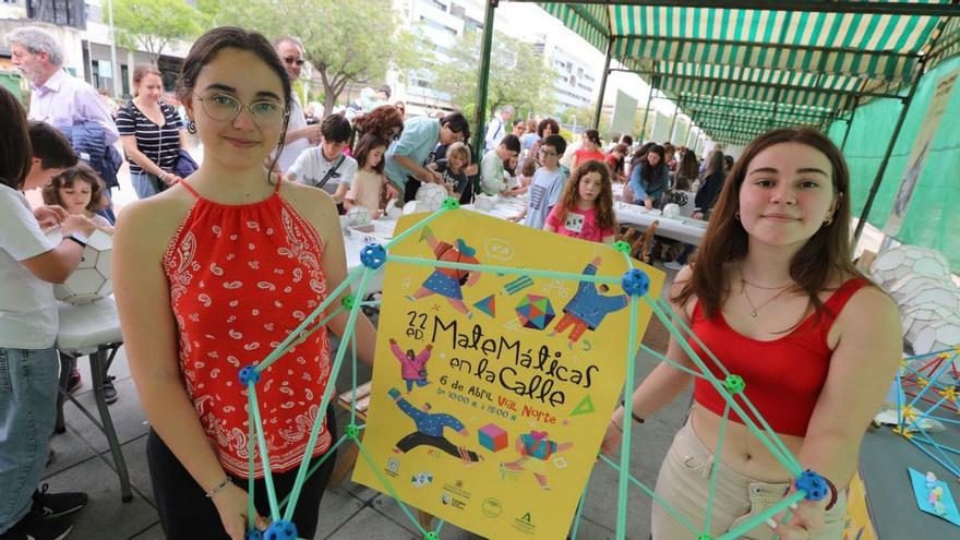 Unas estudiantes con el cartel de la actividad de Matemáticas en la calle.