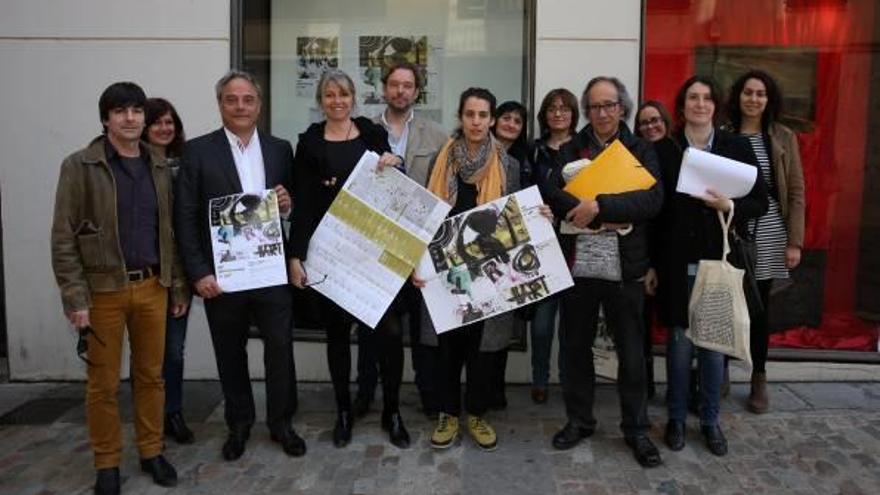 Amb el cartell a la mà: Carles Ribas, Carme Sais i Mar Serinyà, amb els artistes, al Bòlit Pou Rodó de Girona.