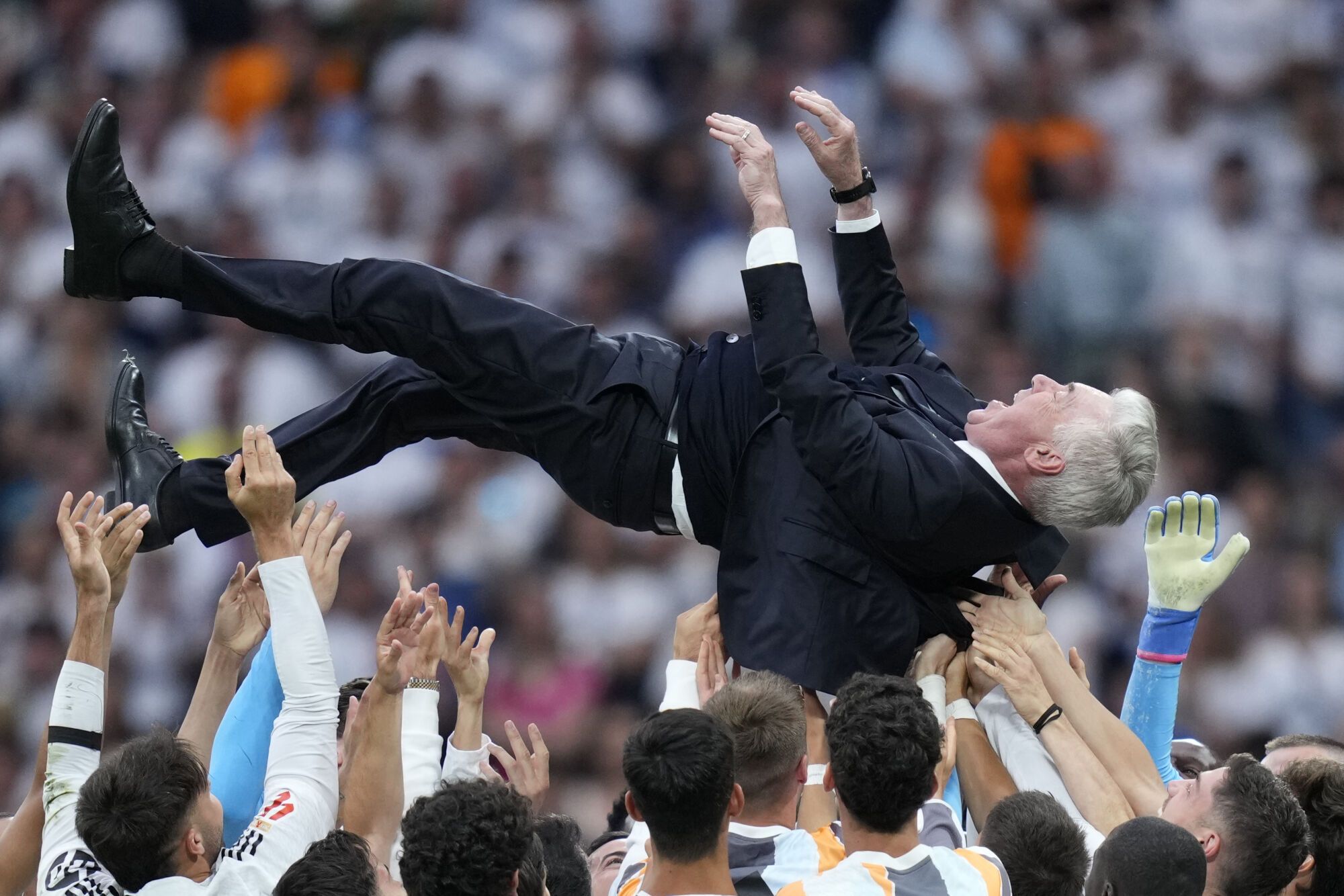 Real Madrid's head coach Carlo Ancelotti is lifted in the air by the players after a Spanish La Liga soccer match against Real Sociedad at Santiago Bernabeu stadium in Madrid, Saturday, May 24, 2025. (AP Photo/Cesar Cebolla)