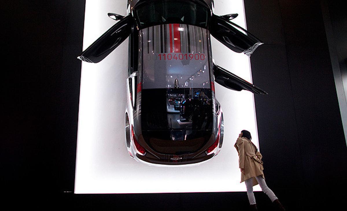 Un visitant observa un cotxe penjat en una paret en una fira de cotxes d’importació a Pequín.