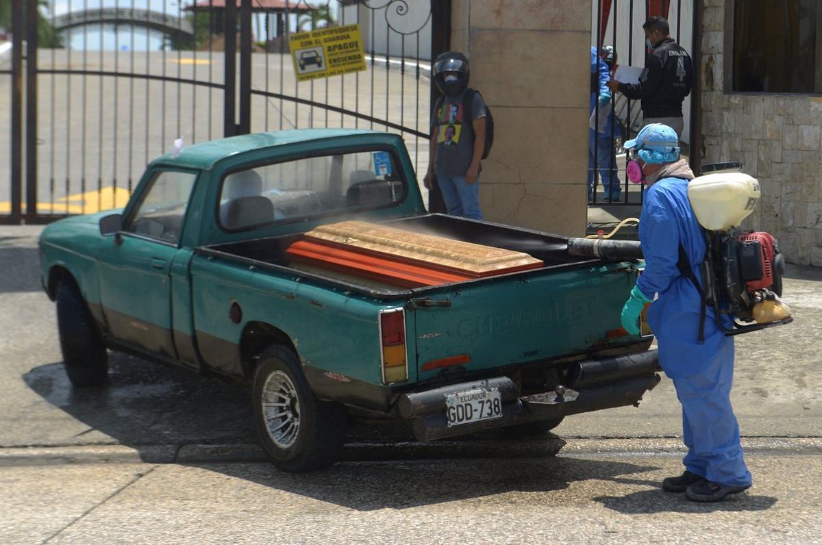 AME9499. GUAYAQUIL (ECUADOR), 01/04/2020.- Féretros con fallecidos que debían ser recogidos por las autoridades para ser enterrados, son desinfectados este miércoles a su llegada a un cementerio de Guayaquil (Ecuador). La fulminante propagación del coronavirus en la zona de Guayaquil, una de las ciudades del mundo más castigadas por el coronavirus per cápita, ha creado una situación de abandono de cadáveres que las autoridades tratan de resolver. EFE/Marcos Pin