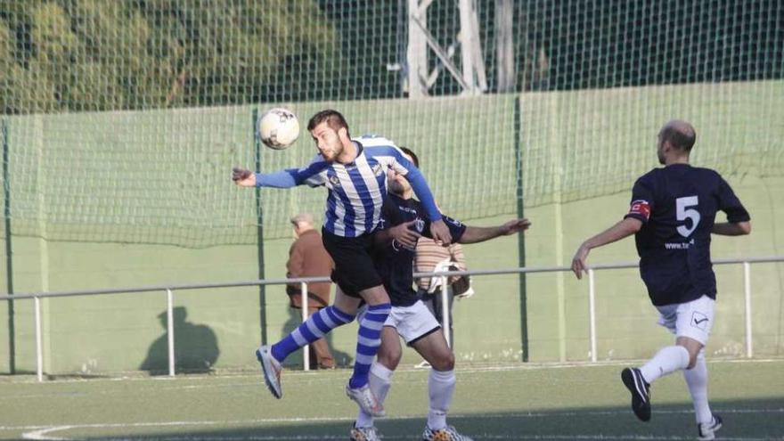 Un jugador del Rápido Bahía despeja el balón ante la presión de uno del Candeán. // Santos Álvarez