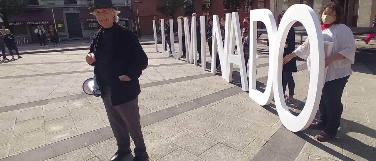 Alain Arias-Misson, ayer, en la plaza del Ayuntamiento, junto a su “iluminado” poema callejero . | D. M.