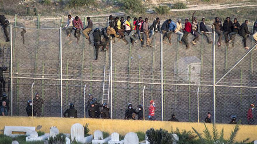 Inmigrantes encaramados a la valla de Melilla.