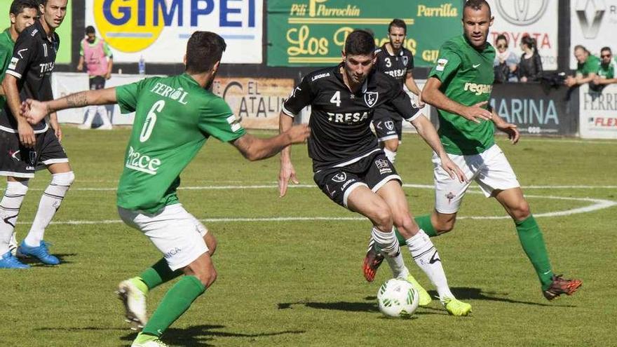 Mendi, que causa baja por amonestaciones, entre dos jugadores del Racing de Ferrol.