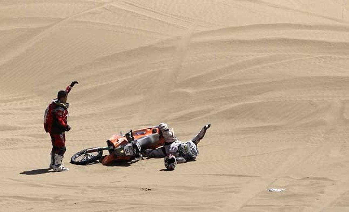 El motociclista xinès Baohua Han s’atura per ajudar el seu col·lega francès Meffre Laurent després que patís una caiguda a la setena etapa --entre Arica i Antofagasta-- del Ral·li Dakar, a Xile.
