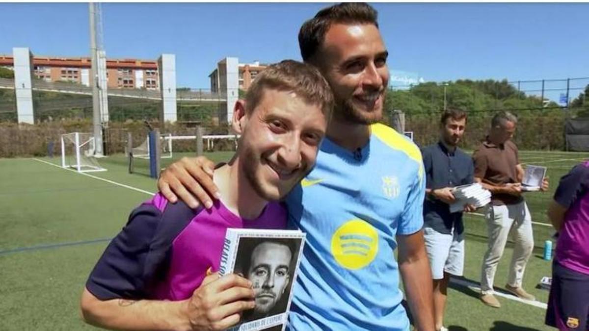 Eric Garcia i un futbolista de l’equip Genuine del Barça amb el llibre de Relats Solidaris