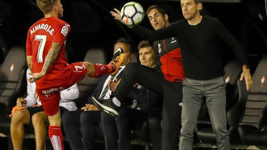 Juan Calos Unzué recoge un balón en presencia del jugador Álvaro Jiménez durante el partido disputado anoche en Balaidos. // Ricardo Grobas