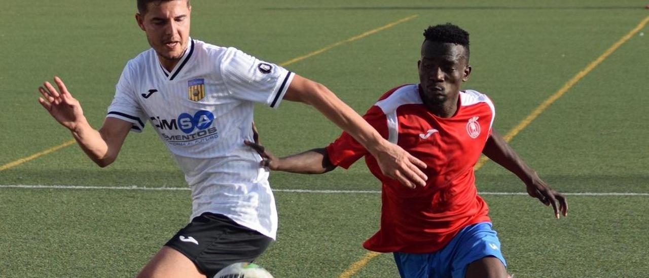 El futbolista de la Vall D'uxó disputa el balón ante el jugador rival.