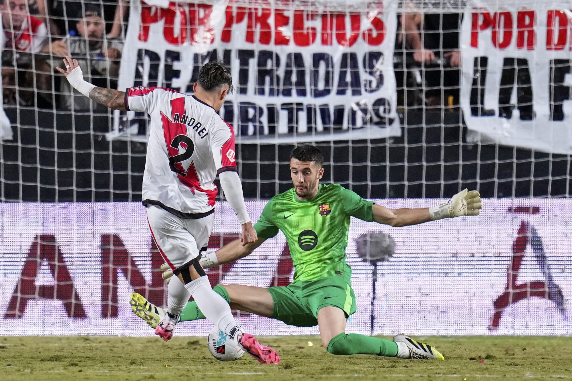 Barcelona's goalkeeper Joan García makes a save from Rayo's Andrei Ratiu during the Spanish La Liga soccer match between Rayo Vallecano and FC Barcelona at the Vallecas stadium in Madrid, Spain, Sunday, Aug. 31, 2025. (AP Photo/Manu Fernandez)