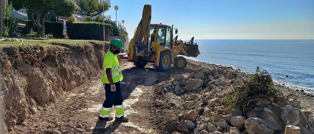 Una excavadora y un operario, ayer, durante los trabajos en el frente litoral entre La Zofra y la desembocadura del río Seco. | J.A.RICO