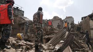 Soldados y equipos de rescate nepalís buscan supervivientes entre los escombros de los edificios caídos tras el terremoto.