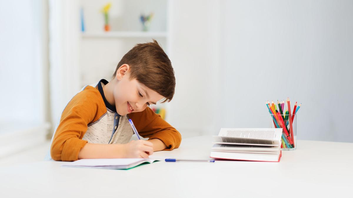 Un niño pinta un cuaderno.
