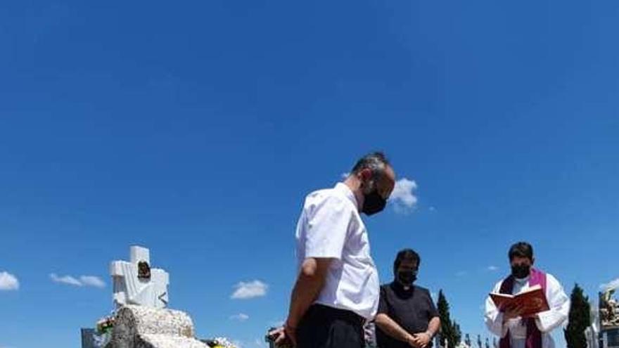 Los párrocos rezan una oración junto al osario del cementerio.