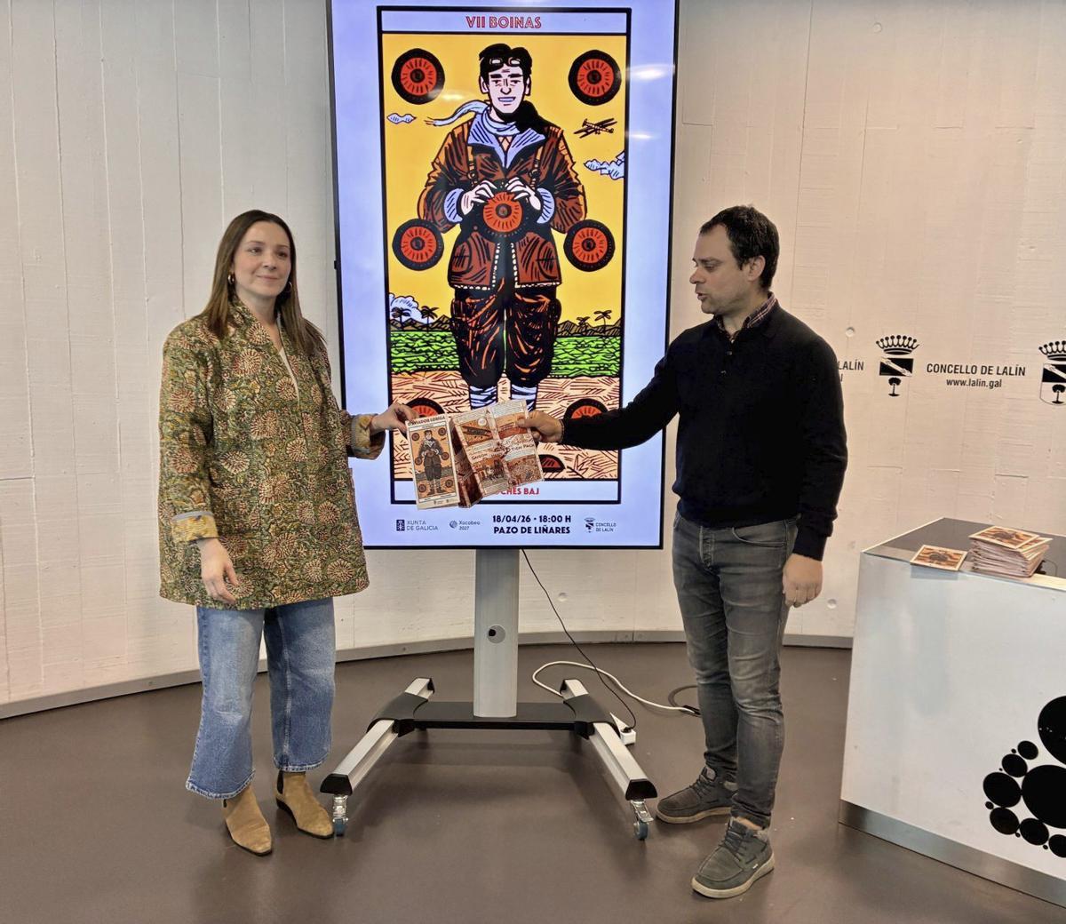 Begoña Blanco e Inacio Vilariño sostienen el cómic de Loriga delante del cartel de las teatralizaciones. | FIRMA