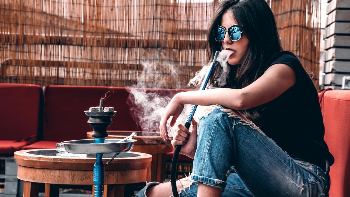Una joven fuma en una cachimba.