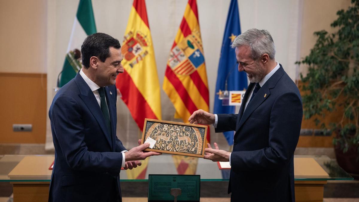 El presidente andaluz, Juan Manuel Moreno Bonilla, entrega una cerámica de la Alhambra al presidente de Aragón, Jorge Azcón.