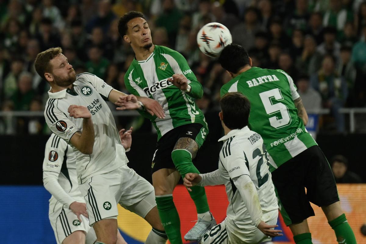 El defensa del Betis Marc Bartra (d) despeja de cabeza.