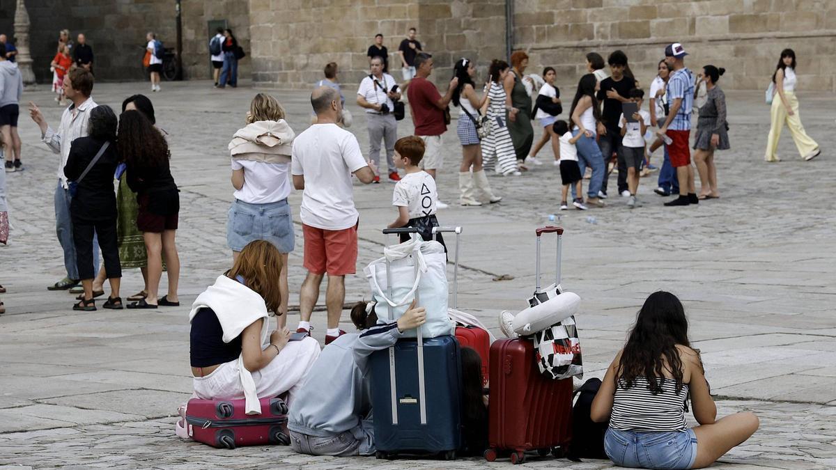 Turistas con sus maletas en la Praza do Obradoiro en Santiago.