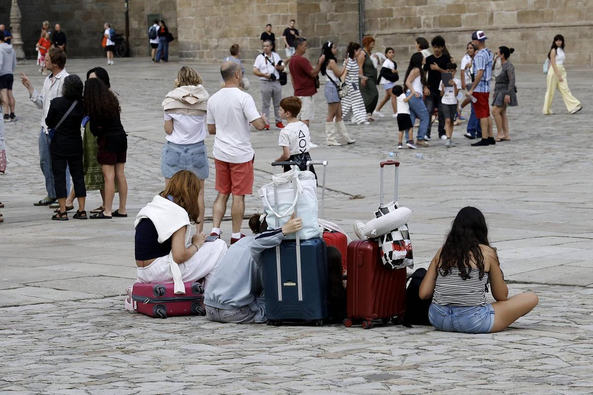 Turistas con sus maletas en la Praza do Obradoiro en Santiago.