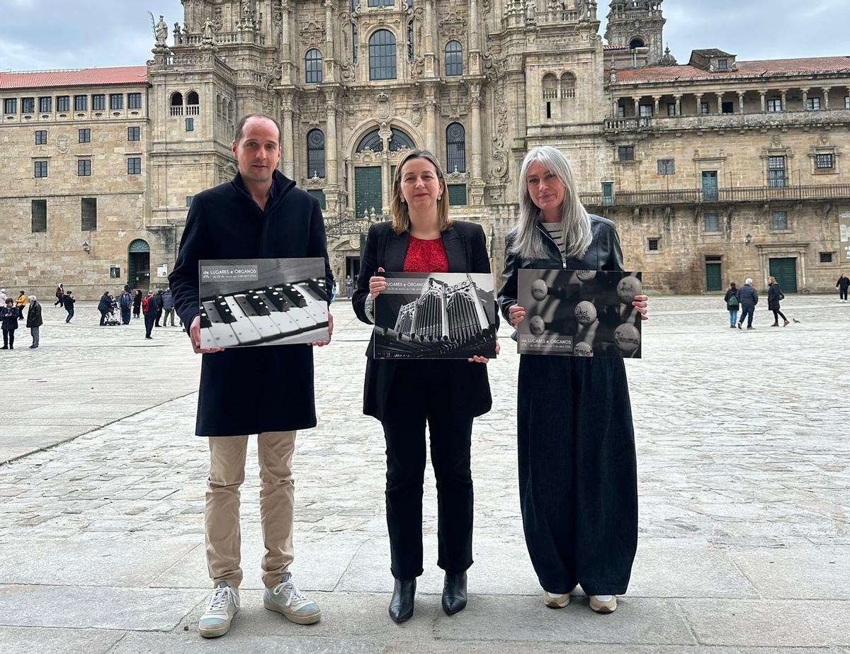 David Fiuza, Míriam Louzao e Belén Bermejo posan no Obradoiro co material gráfico do certame