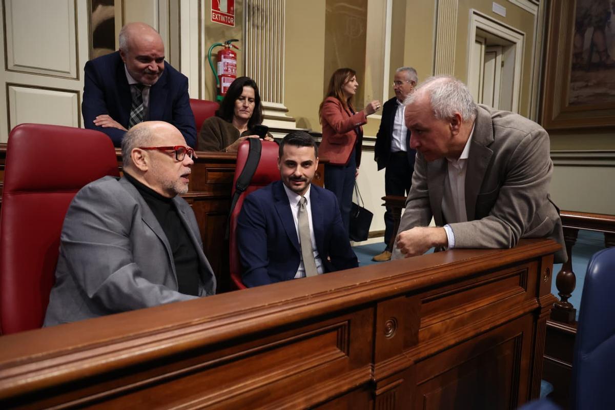 Los nacionalistas José Miguel Barragán (i) y David Toledo (c) conversan con el portavoz de NC-Bc, Luis Campos, antes del pleno del Parlamento.