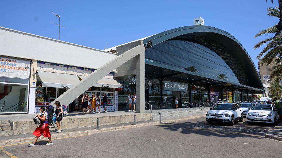 Los taxis esperan a que los viajeros asomen por la puerta de la estación