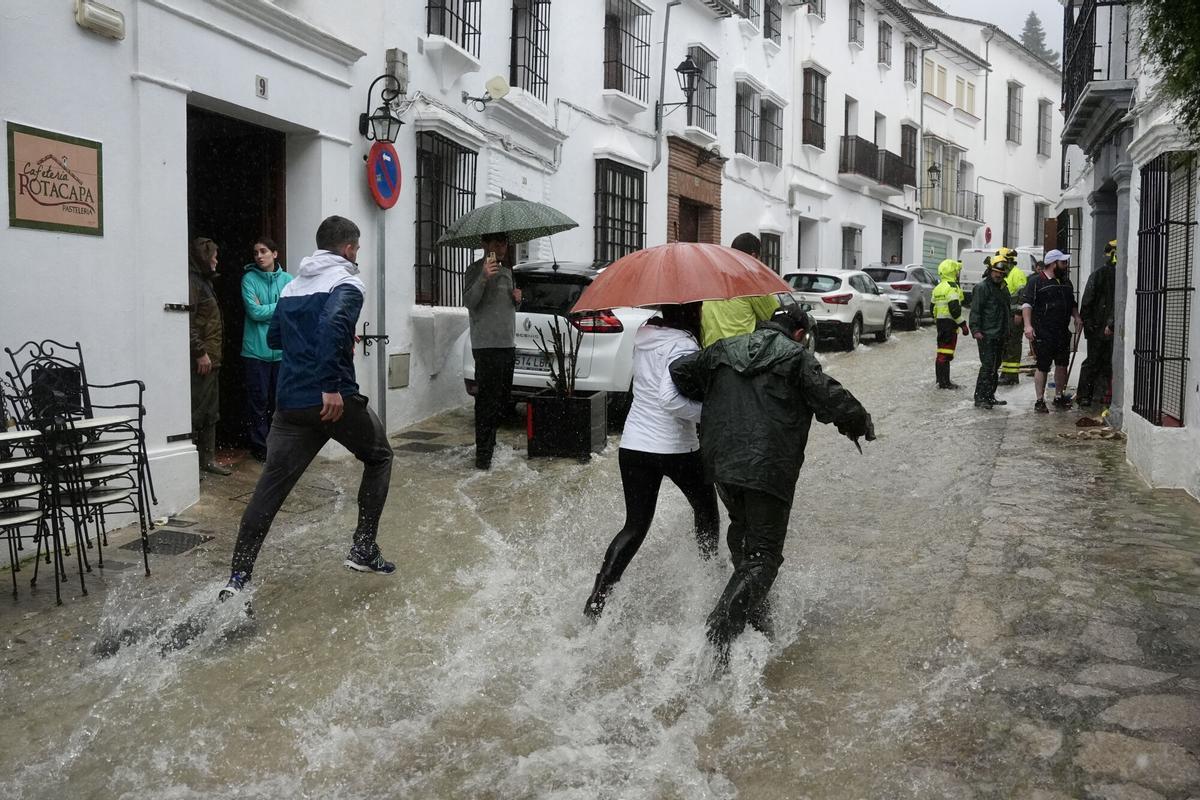 Vecinos de Grazalema corren por una calle inundada