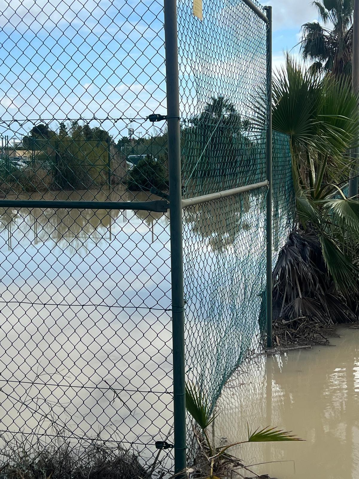 Una de las pistas de tenis totalmente anegada por el agua de las escorrentías provocadas por los accesos al aeropuerto de Alicante-Elche