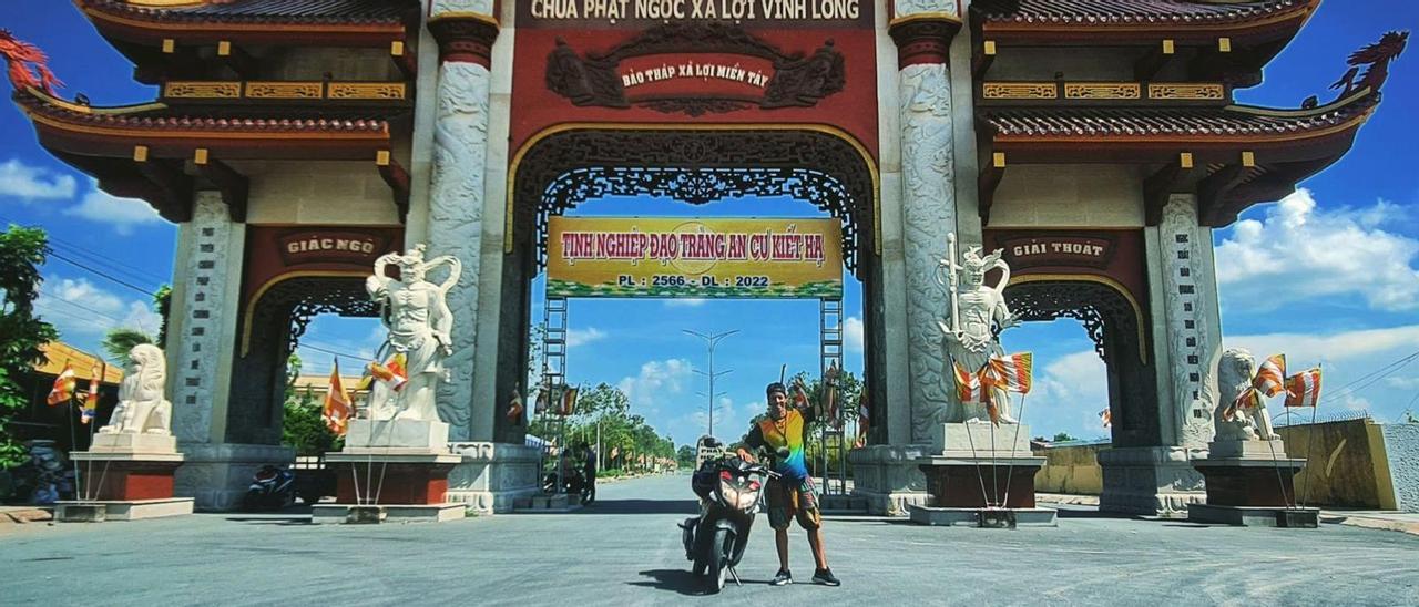 Rober García con su scooter ante la puerta de bienvenida de un pueblo vietnamita.