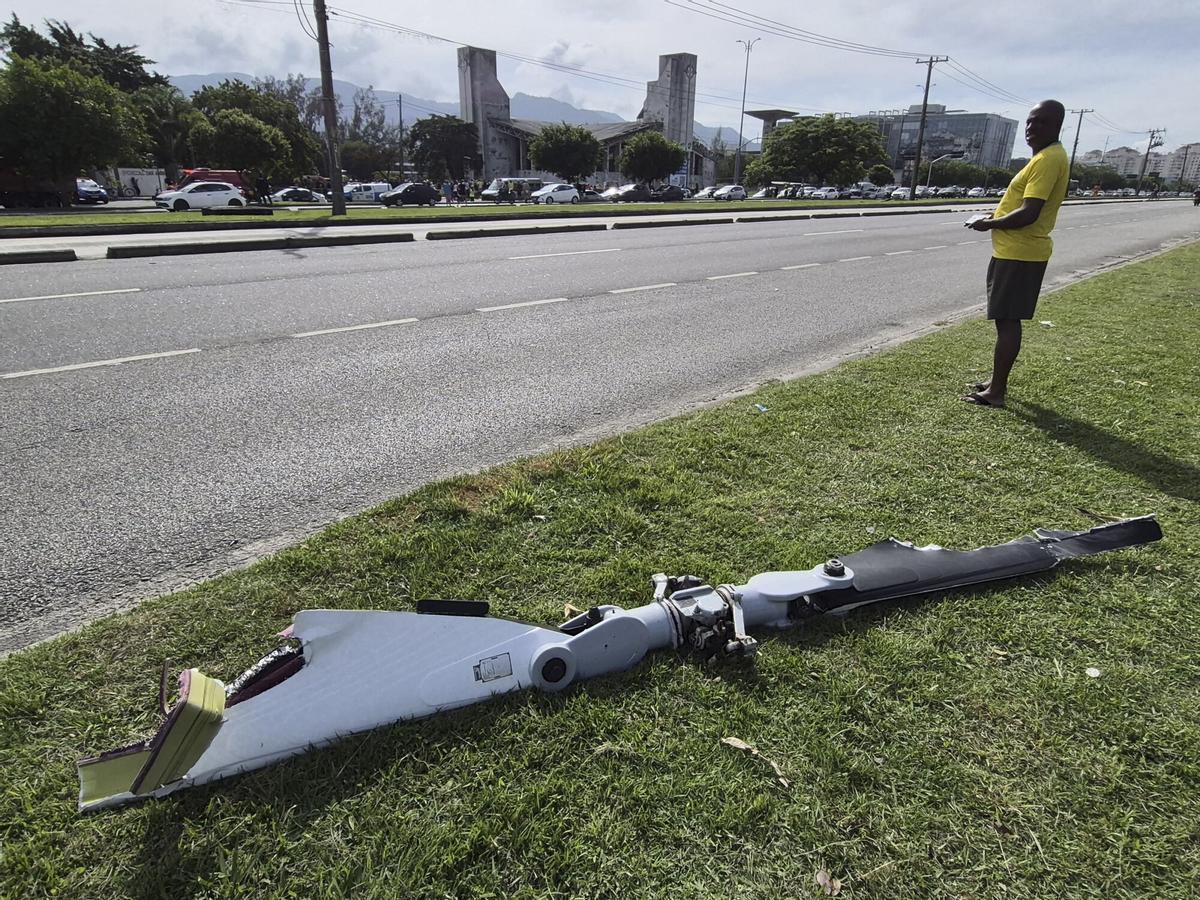 Fotografía cedida este 14 de junio por Roberta Durço que captó a una persona al observar un fragmento de uno de los dos helicópteros que colisionaron este domingo en el aire, en el barrio Recreio dos Bandeirantes, en Río de Janeiro (Brasil). EFE/Roberta Durço. Se añaden fotos del día
