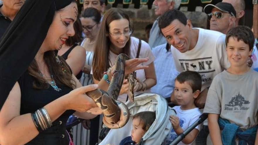 La bailarina con una serpiente se gana la atención de los presentes.