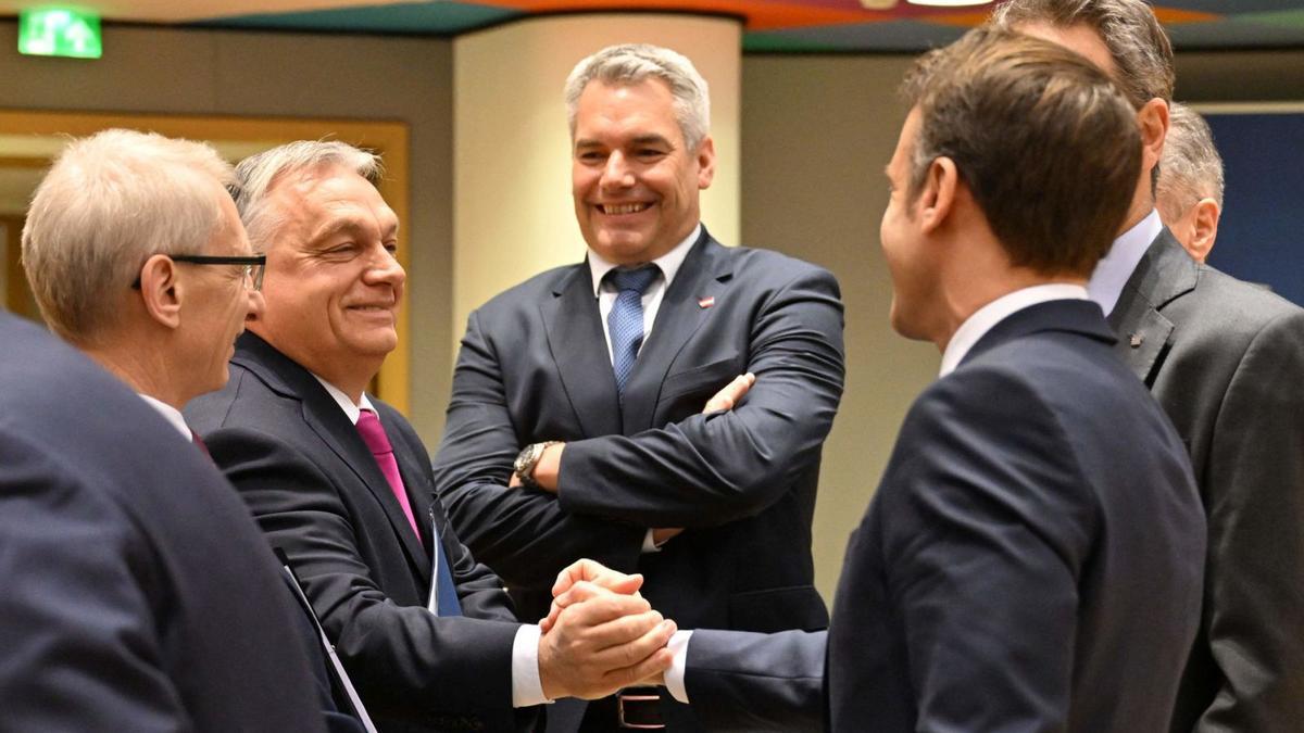 El primer ministre hongarès, Viktor Orbán, i el president francès, Emmanuel Macron, es donen la mà davant el canceller austríac, Karl Nehammer. | MIGUEL MEDINA / AFP