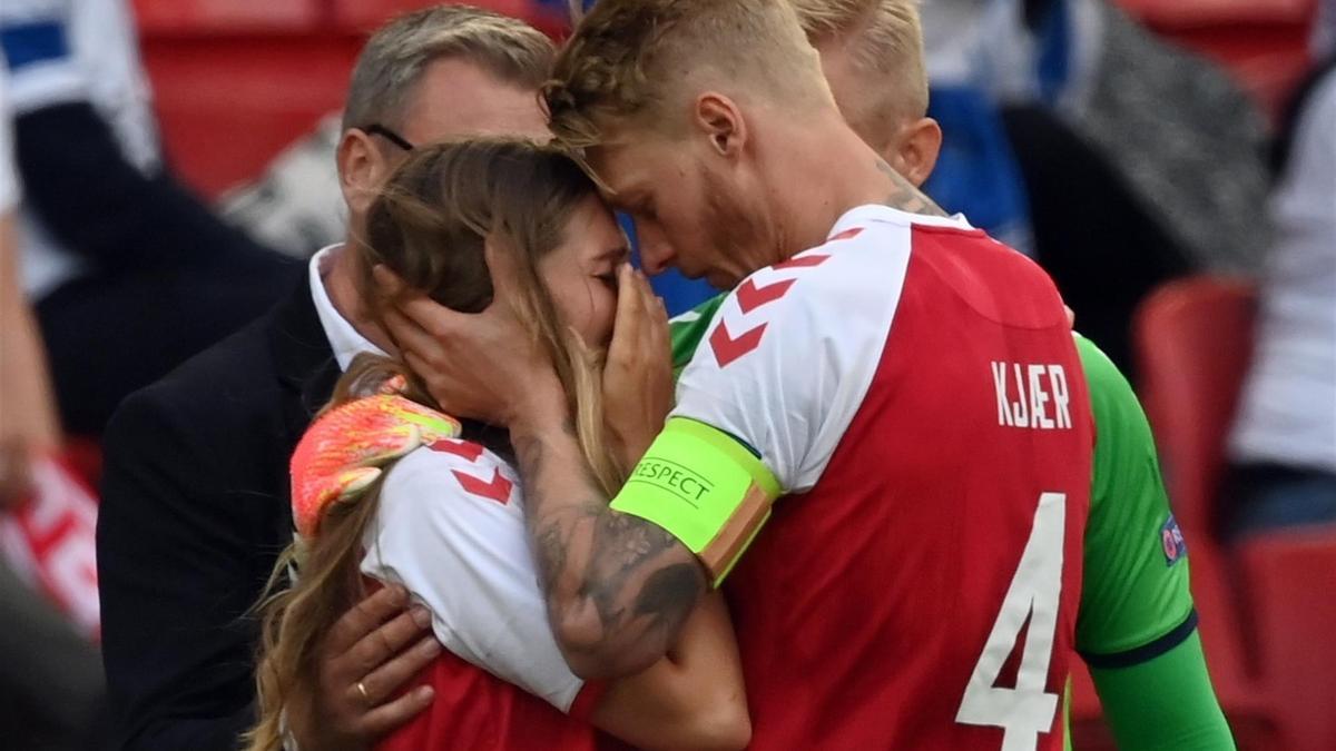 Kjaer abraza a Sabrina Kvist Jensen, novia de Christian Eriksen, sobre el césped del Parken de Copenhague.