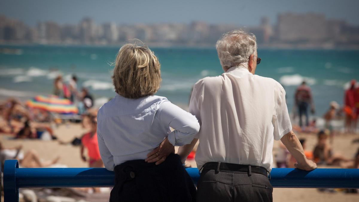 Una pareja de jubilados en la playa del Postiguet de Alicante.