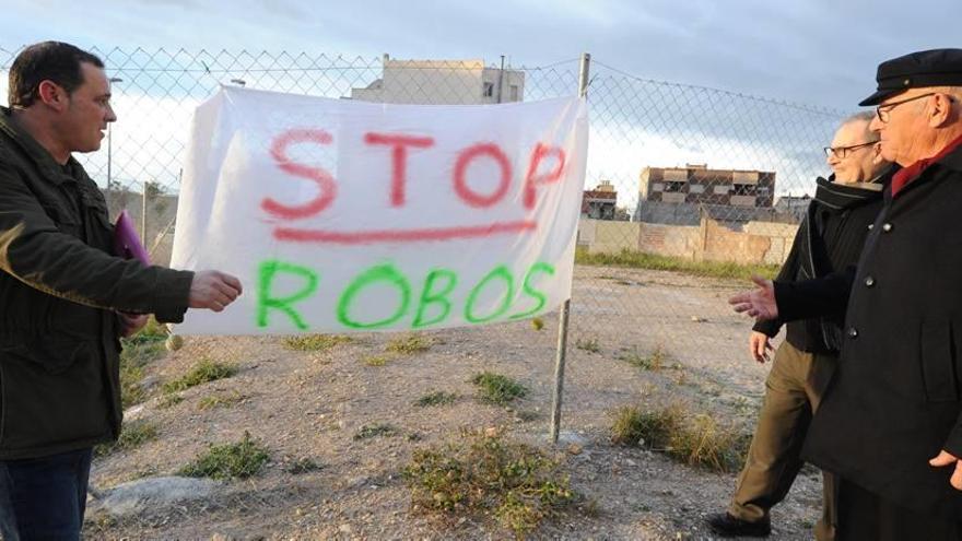 Varios vecinos de El Palmar conversan sobre la inseguridad de la pedanía junto a un cartel en el que se puede leer &#039;Stop robos&#039;.