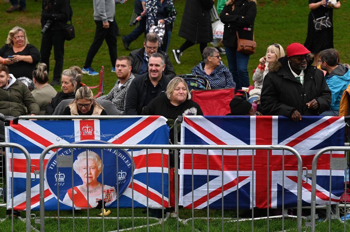 Cientos de ciudadanos se colocan en fila en la ruta hacia Windsor, instantes antes de que empiece el funeral de estado de Isabel II.