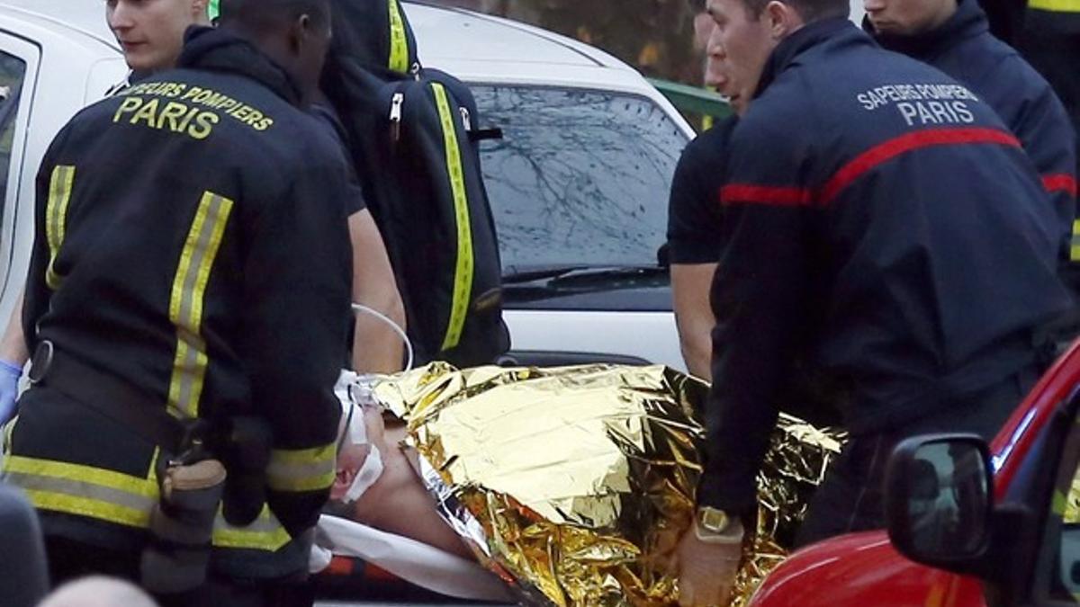 Los sanitarios se llevan al agente herido, tras el tiroteo de ayer, en Motrouge, al sur de París.