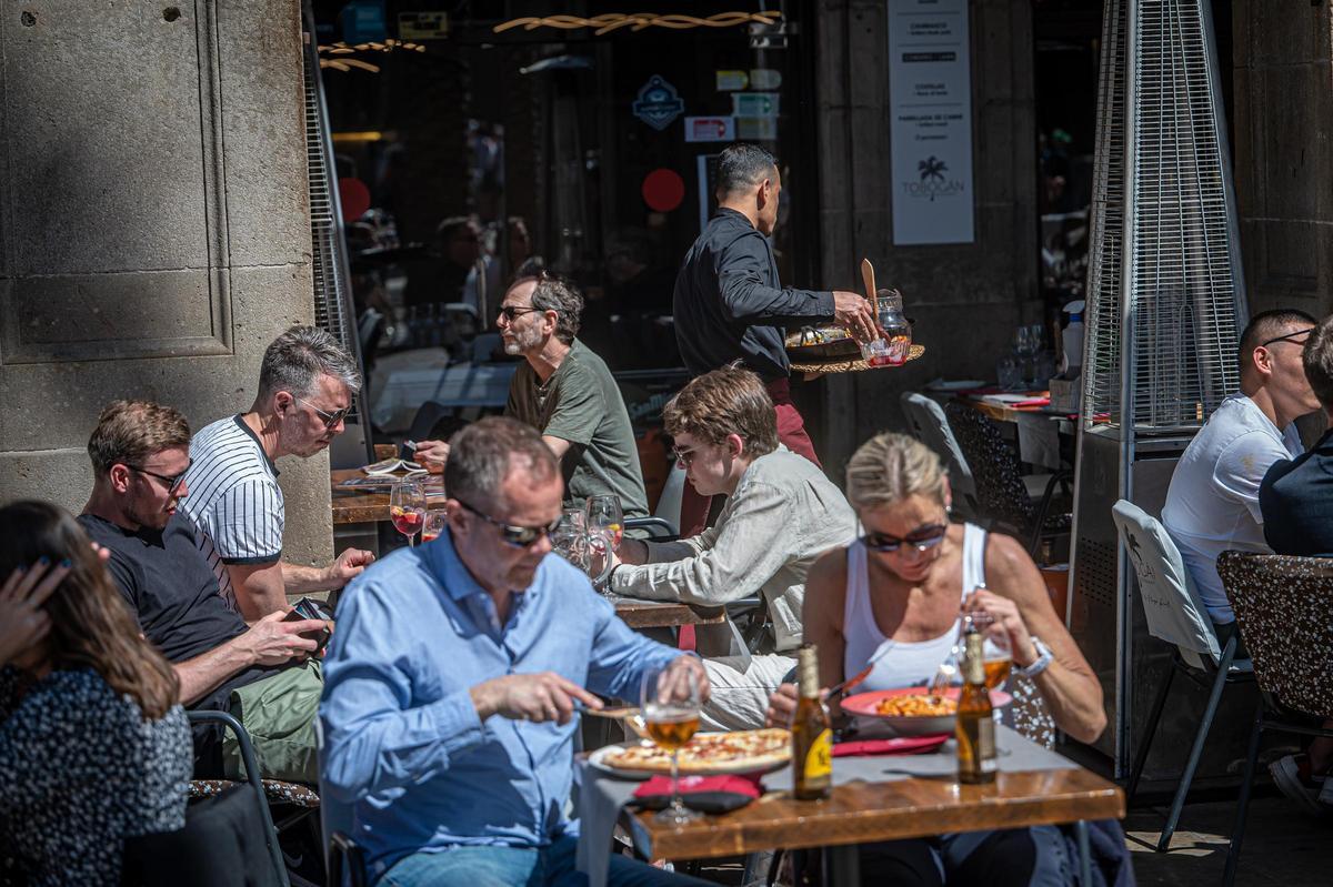 Una pareja come en la terraza de un restaurante de Barcelona.