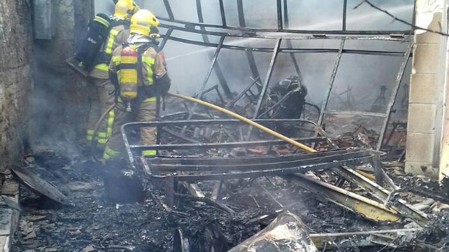 Bombers al lloc de l&#039;incendi, que ha destruït totalment el garatge