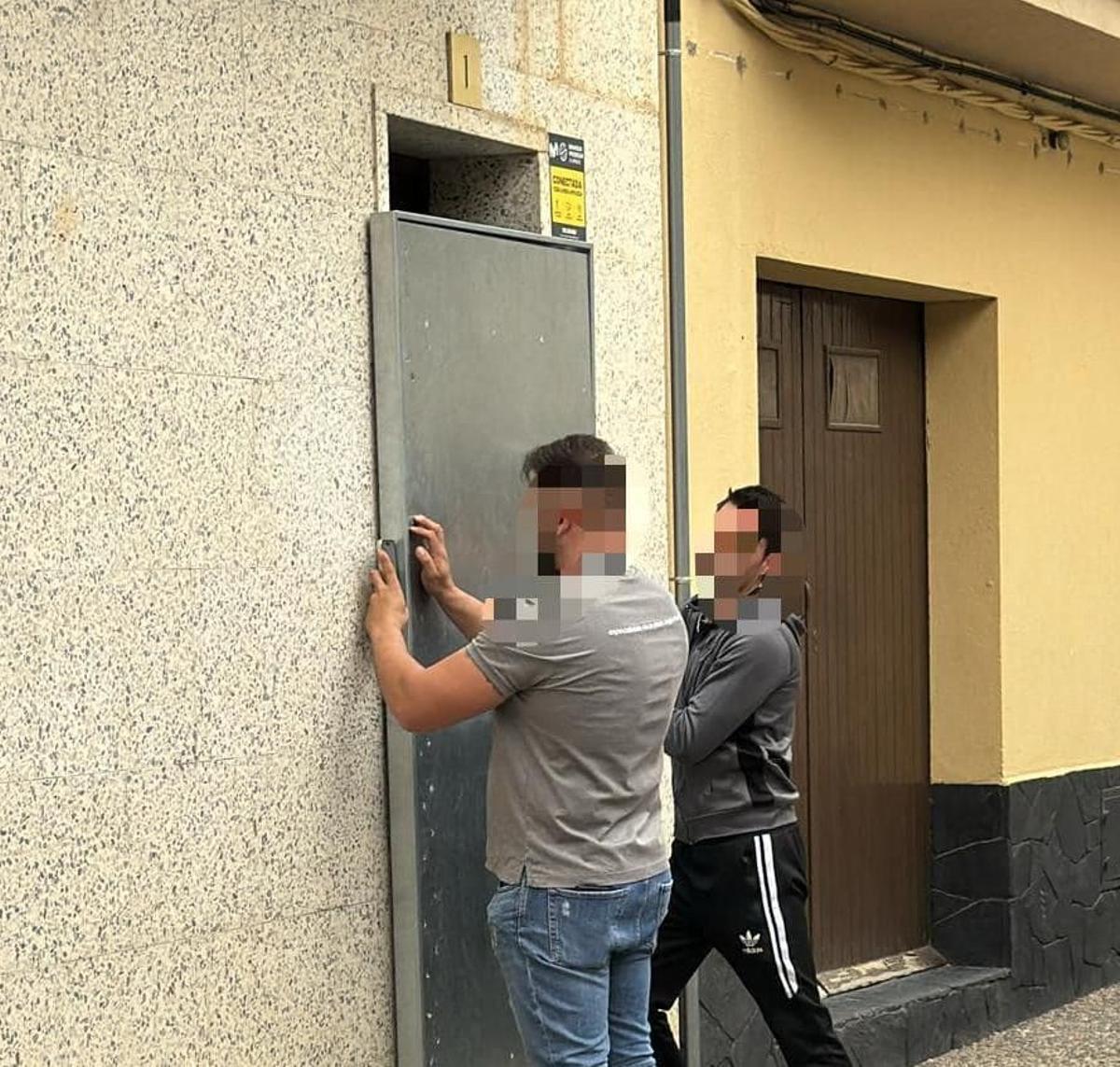 Operaris col·locant una porta antiocupa al bloc desallotjat de Llançà.